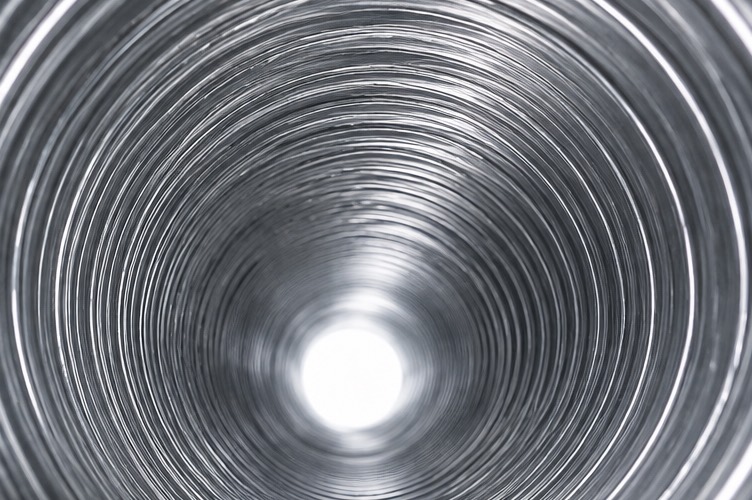 The inside of the same dryer duct after cleaning, bare metal and fully clear